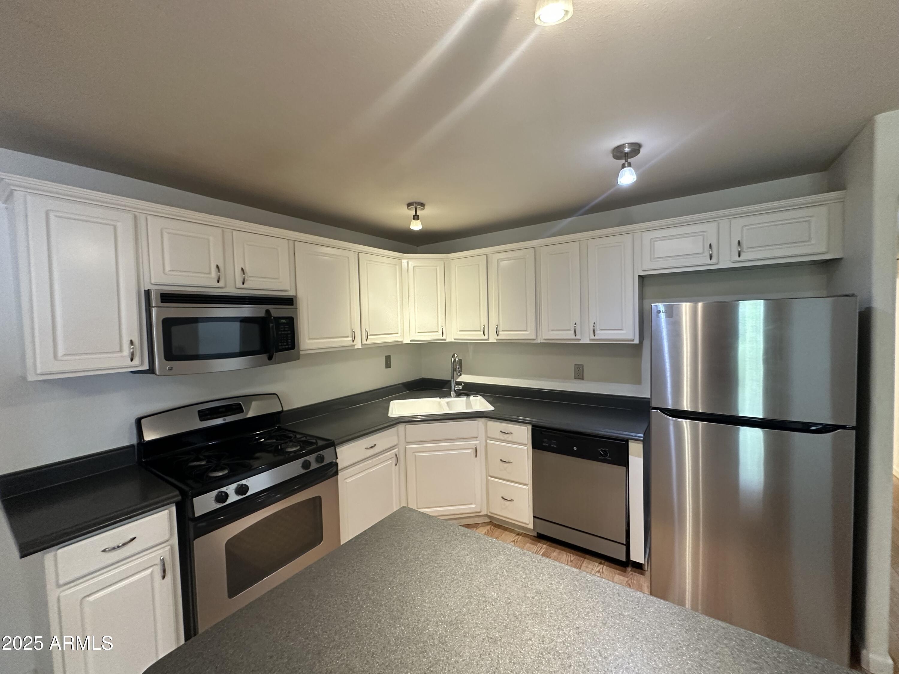 9414 North 17th Street Phoenix, AZ 85020 - Photo 6 of 19 a kitchen with granite countertop a refrigerator stove and microwave
