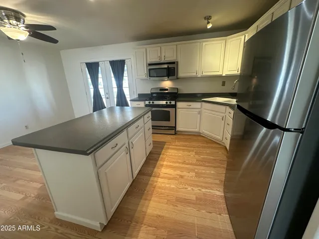 a kitchen with stainless steel appliances granite countertop a refrigerator a stove a sink and a microwave