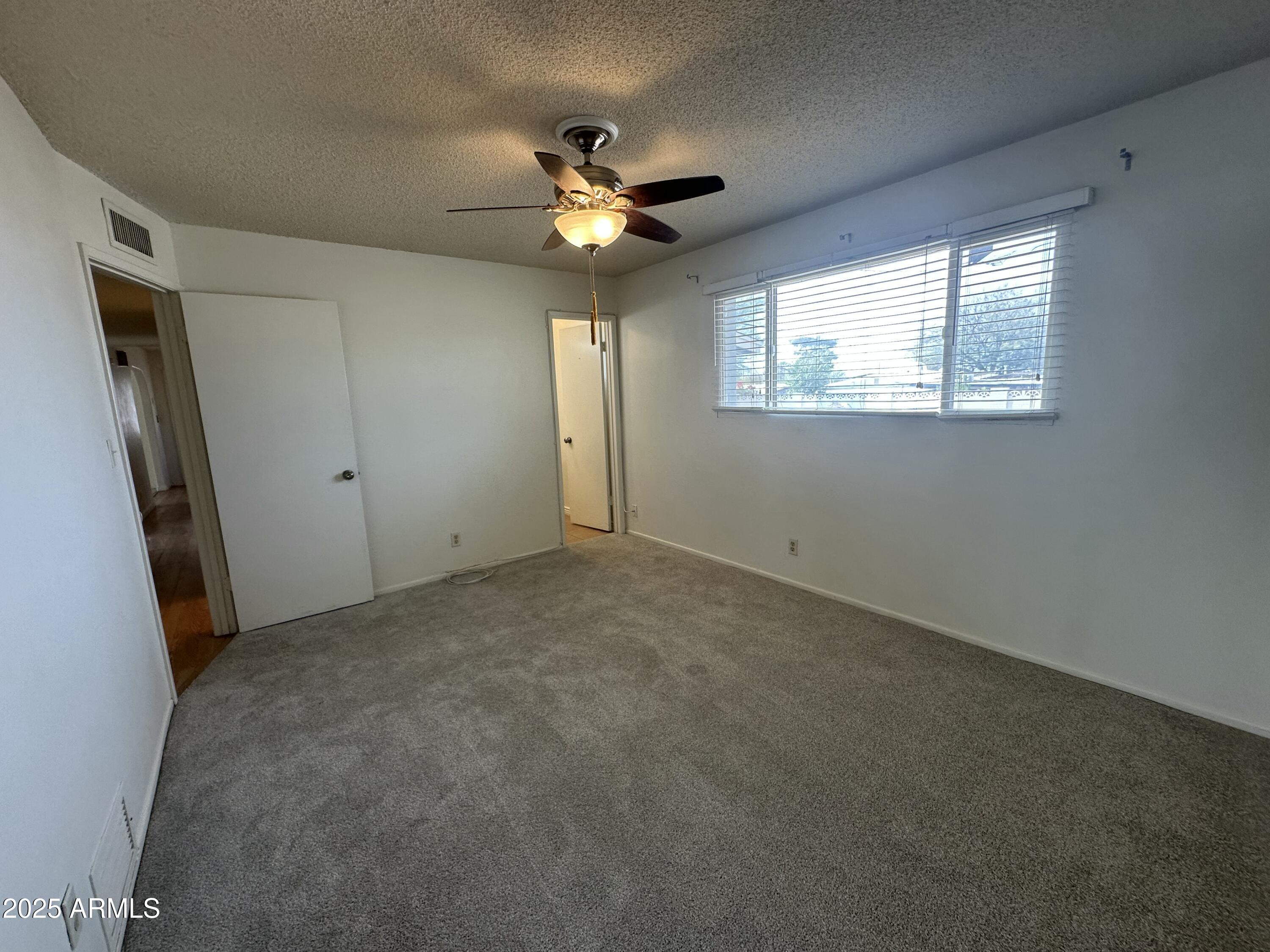 9414 North 17th Street Phoenix, AZ 85020 - Photo 10 of 19 an empty room with windows and fan