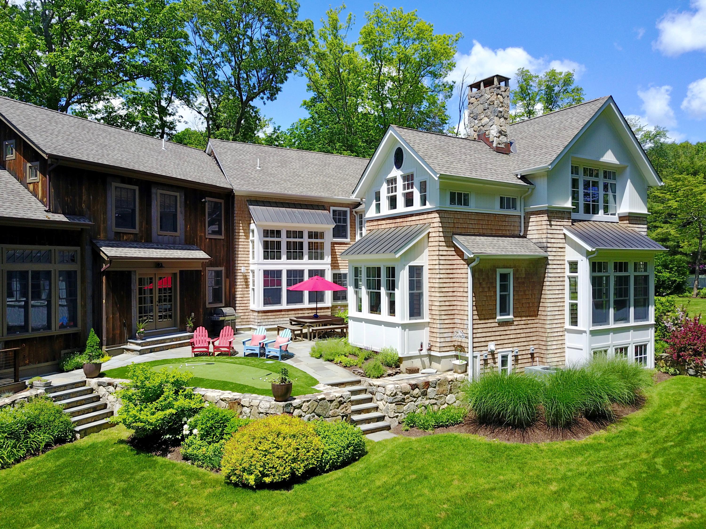 81 Parish Road New Canaan, CT 06840 - Photo 34 of 48 a front view of a house with a yard table and chairs