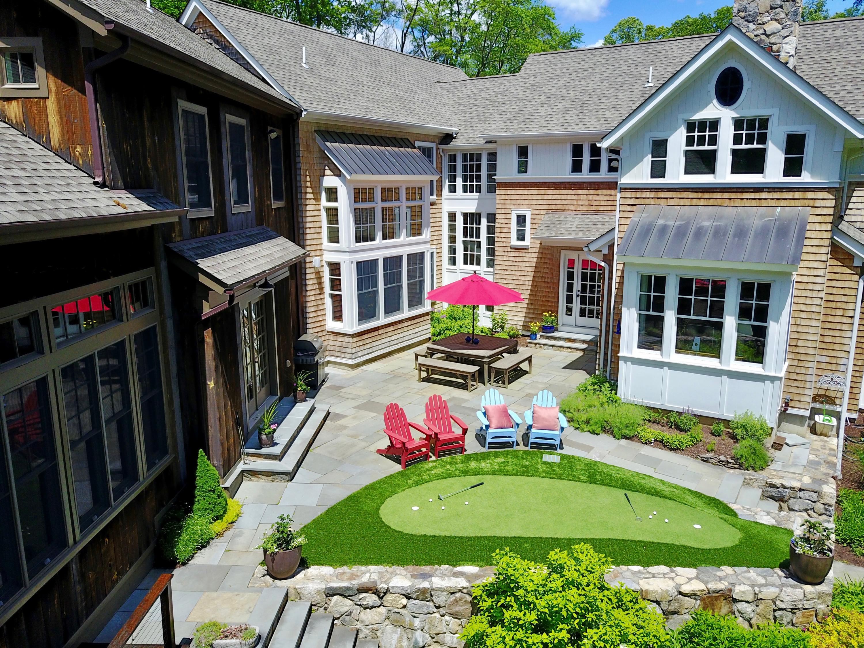 81 Parish Road New Canaan, CT 06840 - Photo 35 of 48 a view of an white house with wooden walls and potted plants