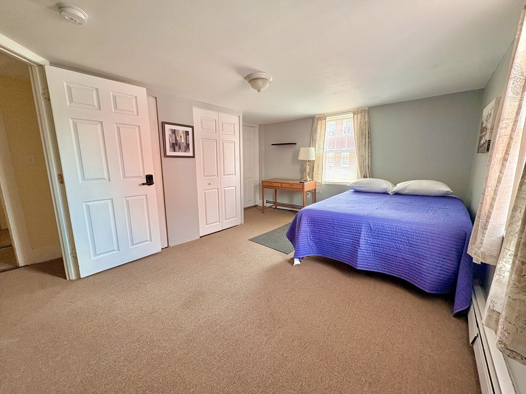 285 Roxbury Street Boston, MA 02119 - Photo 9 of 15 a bedroom with a bed and wooden floor