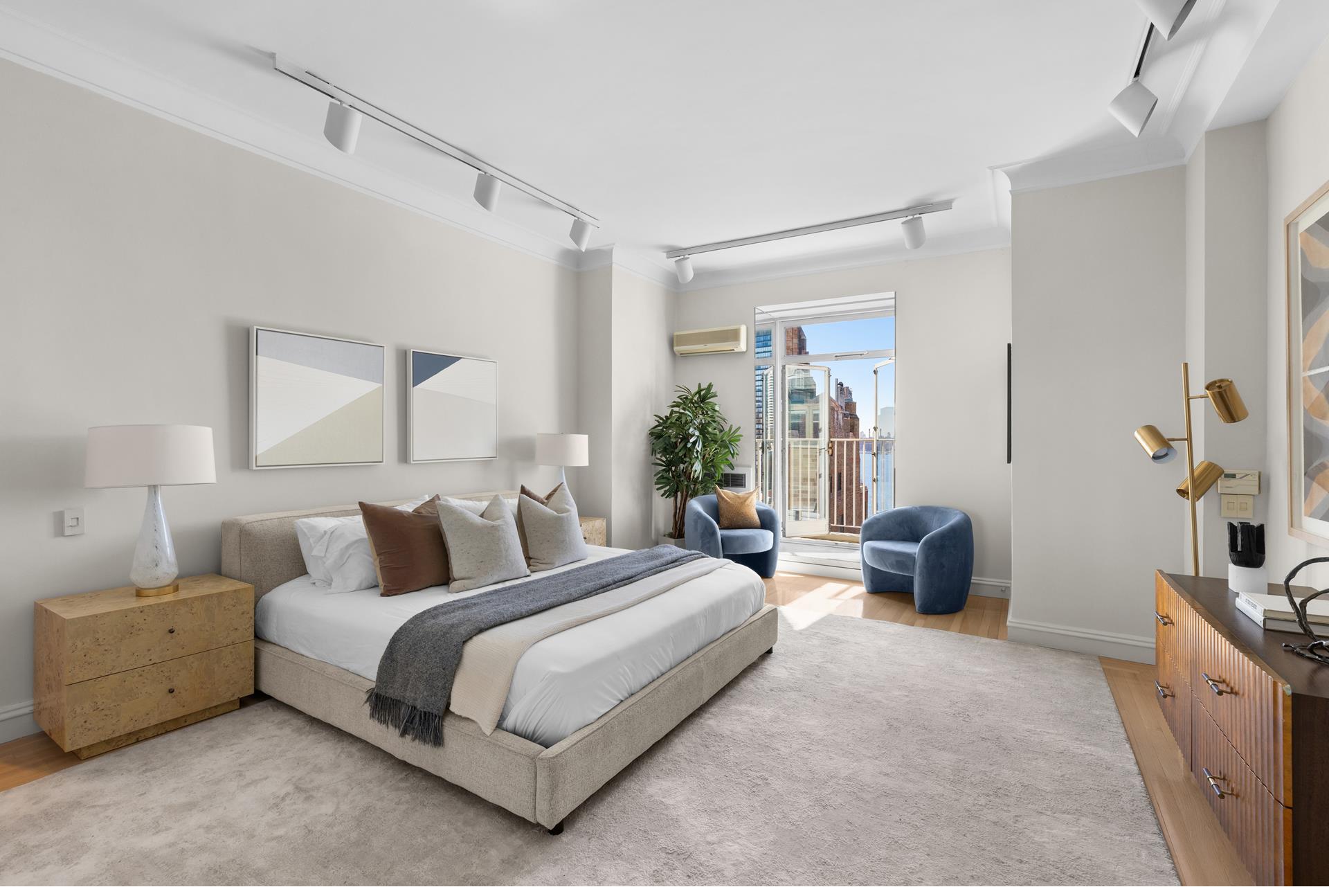 435 East 52nd Street, Unit 15A Manhattan, NY 10022 - Photo 10 of 17 a spacious bedroom with a bed and a couch