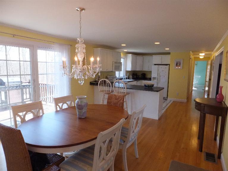 2179 Service Road West Barnstable, MA 02668 - Photo 6 of 26 a view of a dining room and livingroom with furniture wooden floor a chandelier