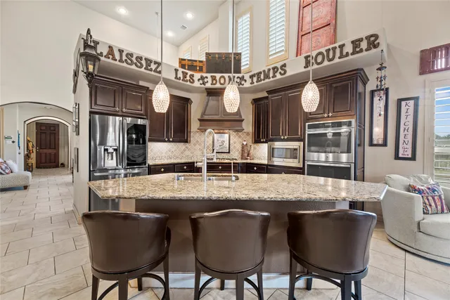 a kitchen with stainless steel appliances granite countertop a stove a sink and a refrigerator