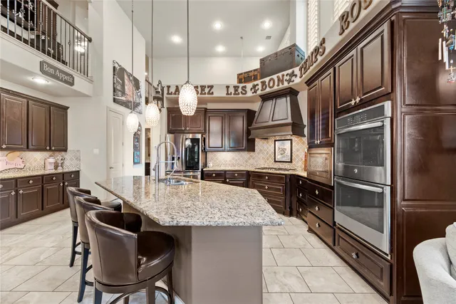 a kitchen with stainless steel appliances granite countertop a sink refrigerator and cabinets