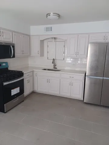 a kitchen with white cabinets and white appliances