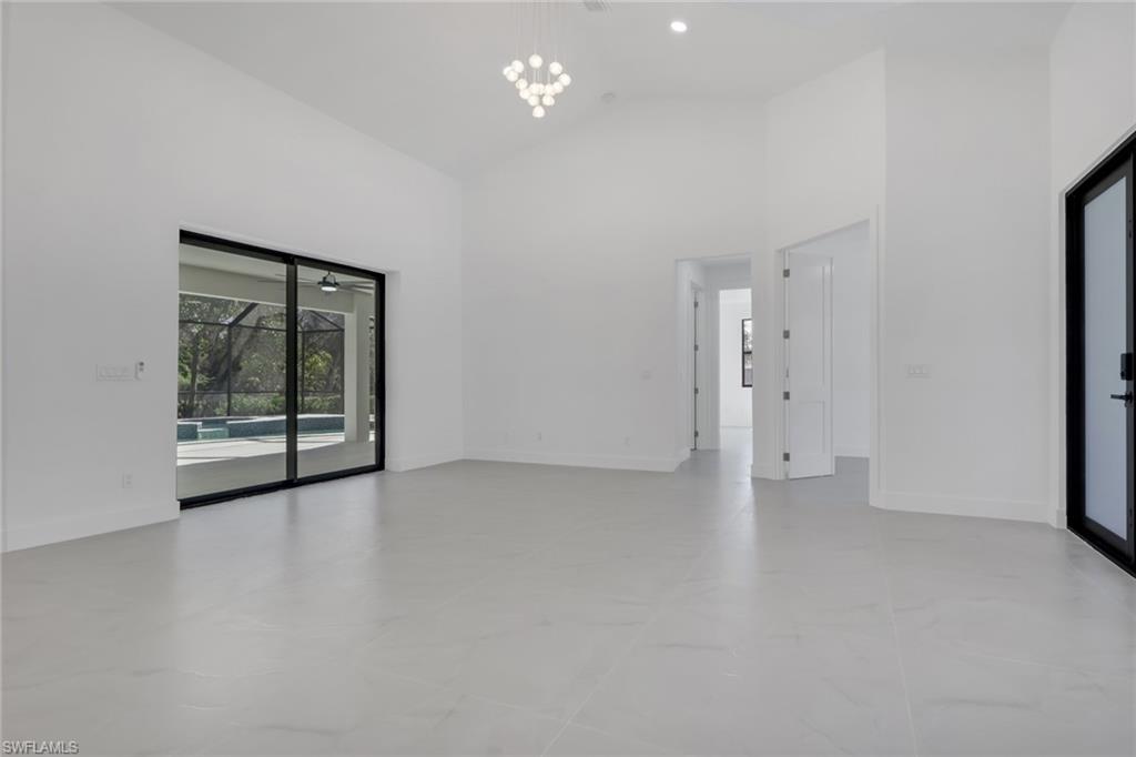 730 29th Street Southwest Naples, FL 34117 - Photo 15 of 50 Unfurnished room with lofted ceiling, a sunroom, and hanging lights