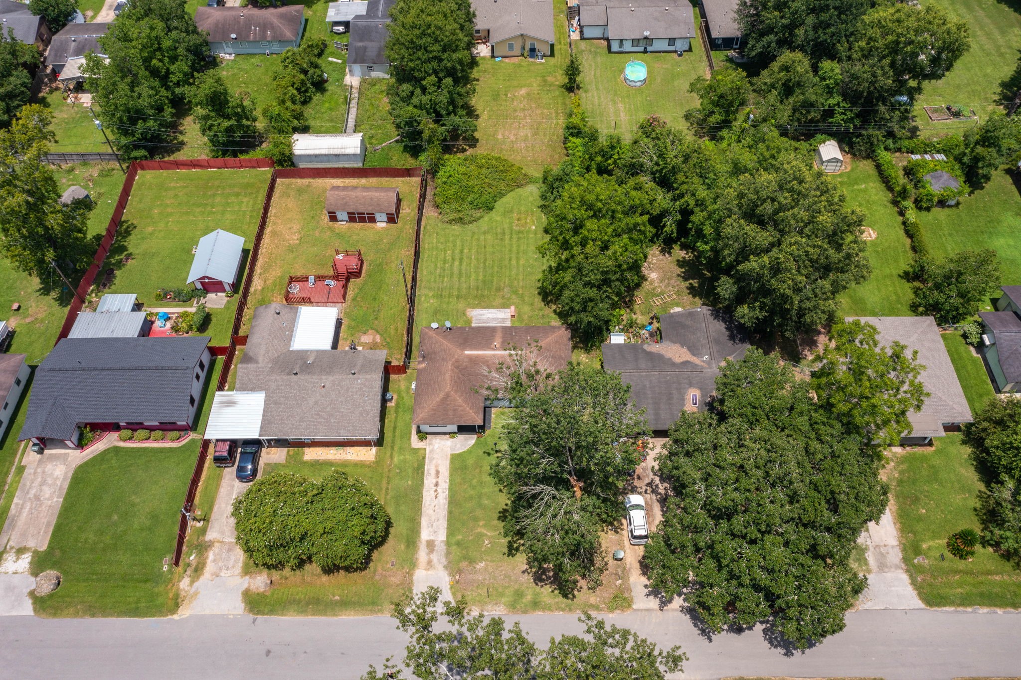 7280 Click Drive Beaumont, TX 77708 - Photo 29 of 39 This aerial view showcases a suburban neighborhood with single-story homes, spacious backyards, and mature trees. The properties are well-maintained, featuring lawns, driveways, and fencing for privacy. Ideal for families seeking a community setting.