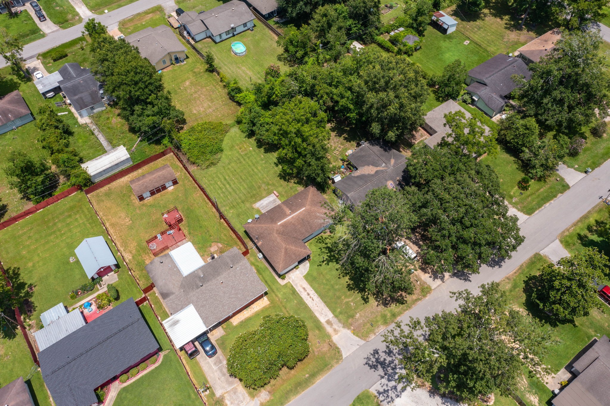 7280 Click Drive Beaumont, TX 77708 - Photo 30 of 39 This aerial view of a residential area showcases spacious yards with mature trees, well-maintained lawns, and a mix of single-story homes. The neighborhood appears peaceful, with ample green space and a layout that offers privacy and comfort.