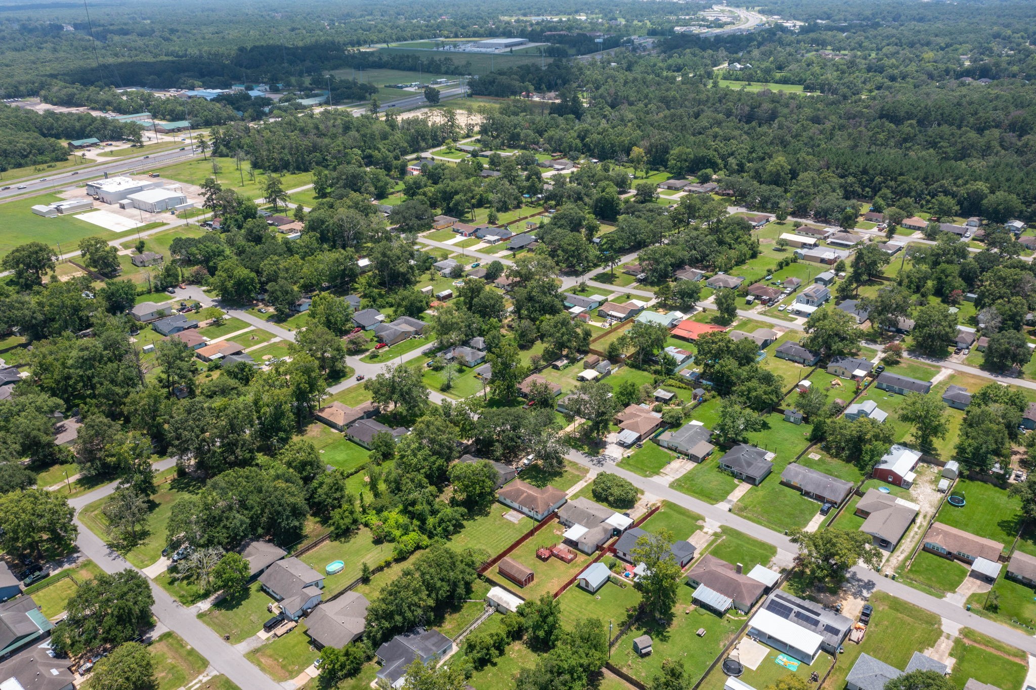 7280 Click Drive Beaumont, TX 77708 - Photo 34 of 39 This aerial view showcases a serene suburban neighborhood, characterized by tree-lined streets and well-spaced homes. The area is lush with greenery, providing a peaceful, community-oriented atmosphere.