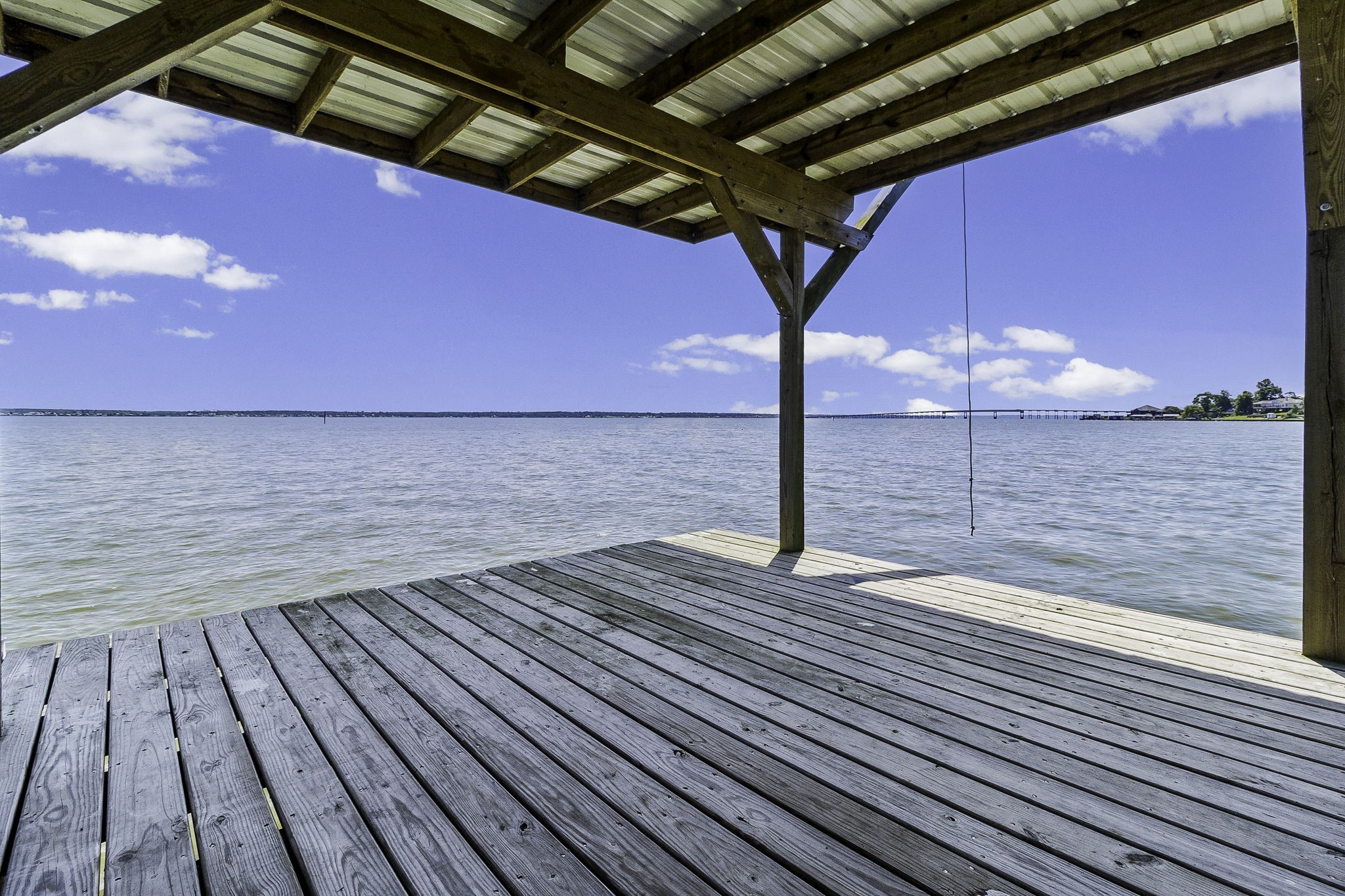 151 Key Largo Loop Point Blank, TX 77364 - Photo 40 of 49 Covered waterfront dock, with panoramic open-water, views, a rope swing for lakeside fun, and an aluminum ladder providing easy access to the water.