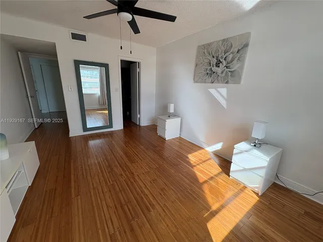 a bedroom with bed and wooden floor