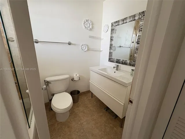 a white toilet sitting next to a bathroom sink