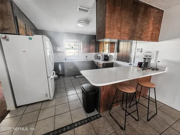 a kitchen with a table chairs and a refrigerator