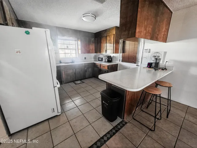 a kitchen with stainless steel appliances granite countertop a sink a stove a refrigerator and cabinets