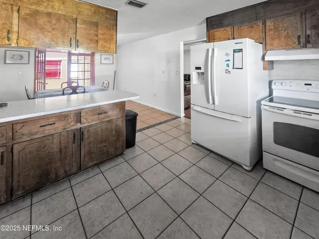 a kitchen with stainless steel appliances a refrigerator sink and cabinets