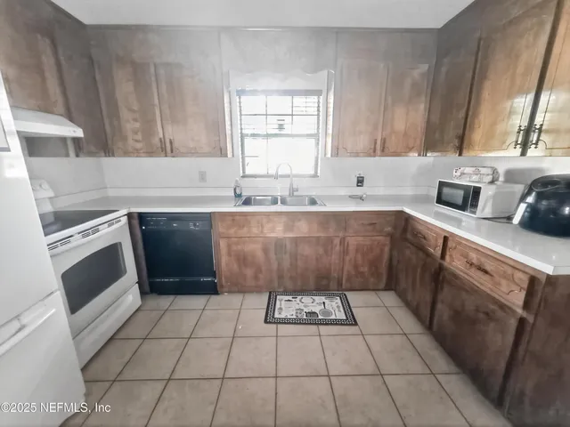 a kitchen with a sink a stove a microwave and cabinets