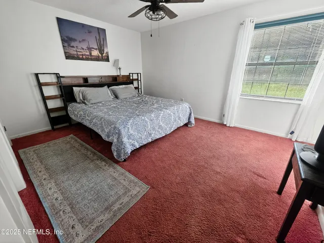 a bedroom with a bed rug and window