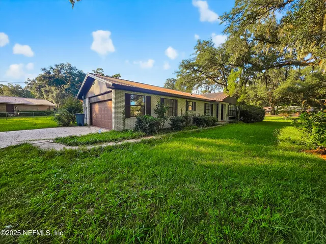 a front view of house with yard and green space