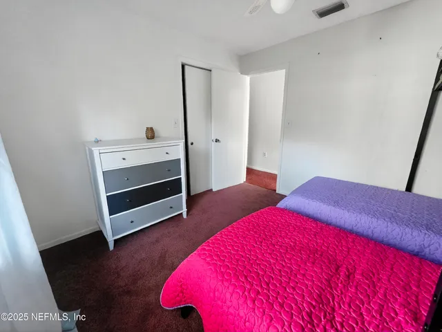 a bedroom with two bed and a flat tv screen on dresser