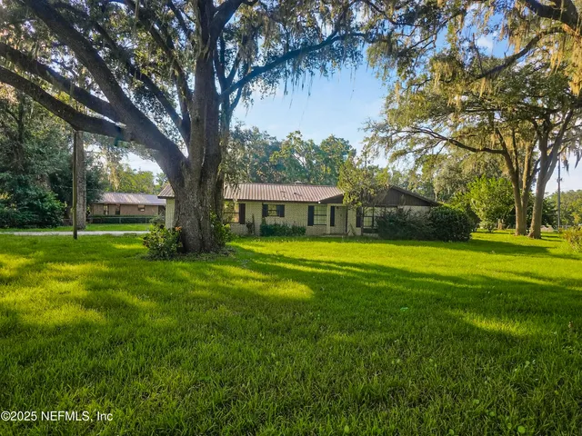 a view of house with a yard