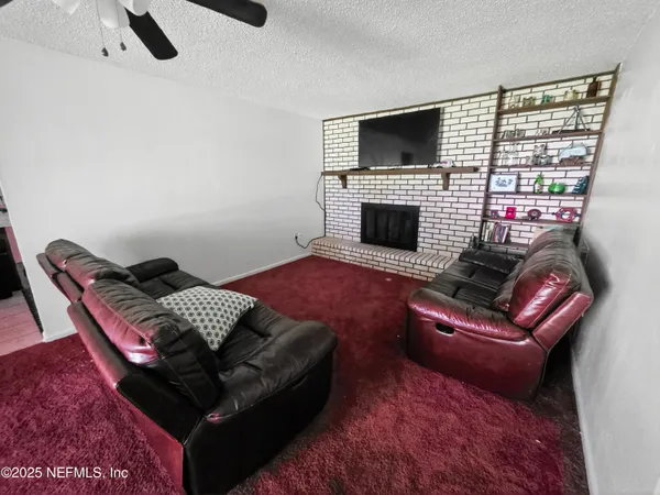 a living room with furniture a flat screen tv and a fireplace