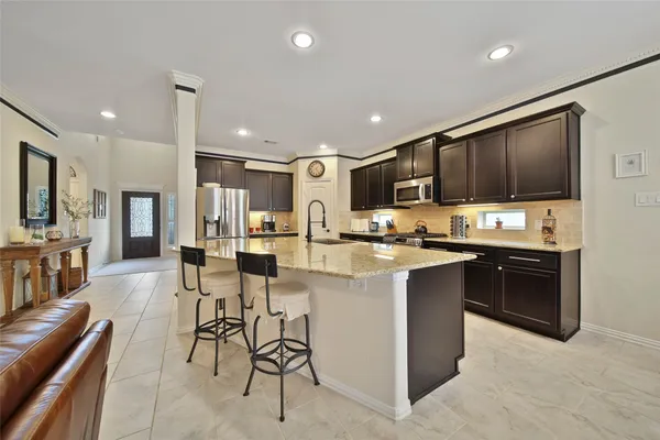 a kitchen with stainless steel appliances kitchen island granite countertop a sink and cabinets