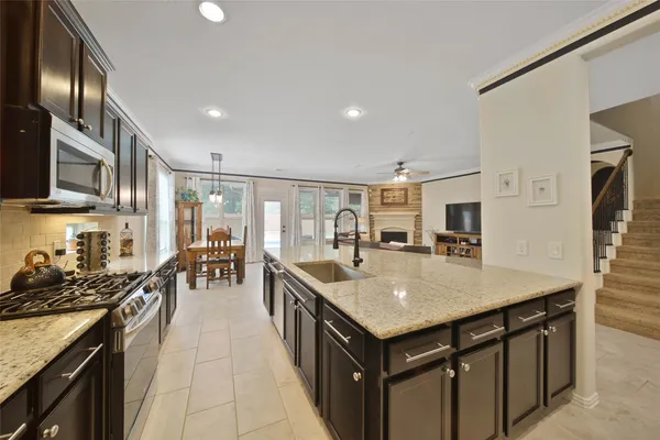 a kitchen with stainless steel appliances granite countertop a sink a stove and a refrigerator