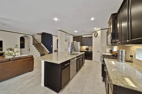 a kitchen with stainless steel appliances granite countertop a sink a stove and a refrigerator