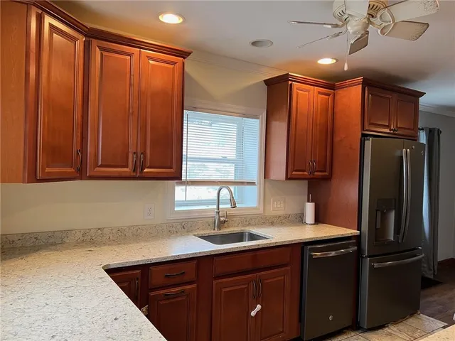 a kitchen with stainless steel appliances granite countertop a refrigerator and a sink
