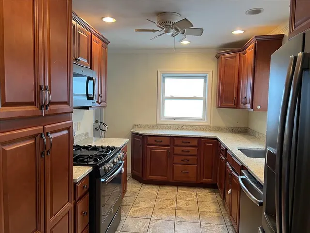 a kitchen with stainless steel appliances granite countertop a stove a sink dishwasher and a refrigerator