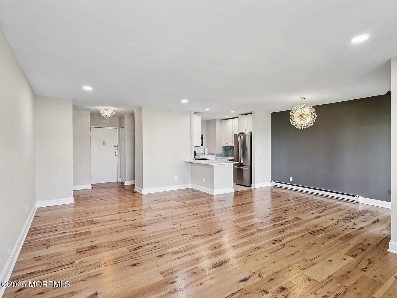 1111 River Road, Unit H20 Edgewater, NJ 07020 - Photo 3 of 14 a view of an empty room with wooden floor and kitchen appliances