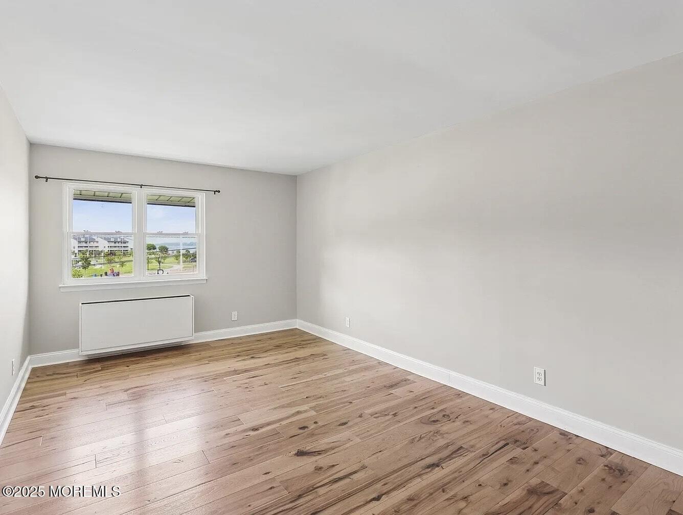1111 River Road, Unit H20 Edgewater, NJ 07020 - Photo 4 of 14 wooden floor in an empty room with a window