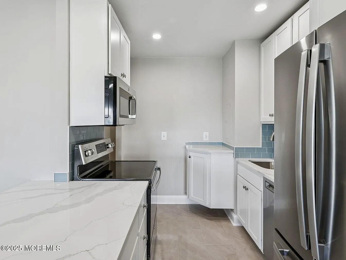 1111 River Road, Unit H20 Edgewater, NJ 07020 - Photo 7 of 14 a kitchen with stainless steel appliances kitchen island a refrigerator sink and stove