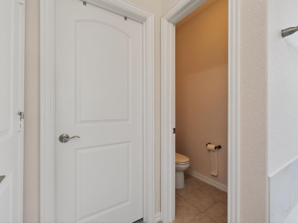 636 Corner Post Path Celina, TX 75009 - Photo 22 of 40 Compact water closet featuring a standard toilet, beige wall paint, and tiled flooring