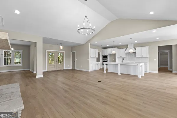 a view of kitchen with center island stainless steel appliances wooden floor and living room view