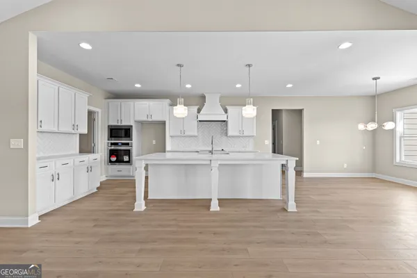 a kitchen with kitchen island white cabinets and refrigerator