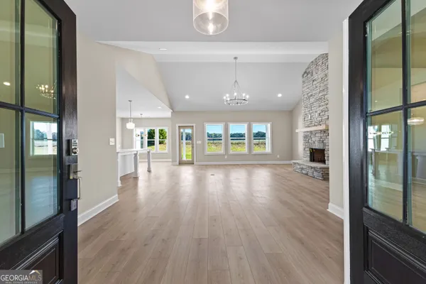 an empty room with wooden floor fireplace and windows