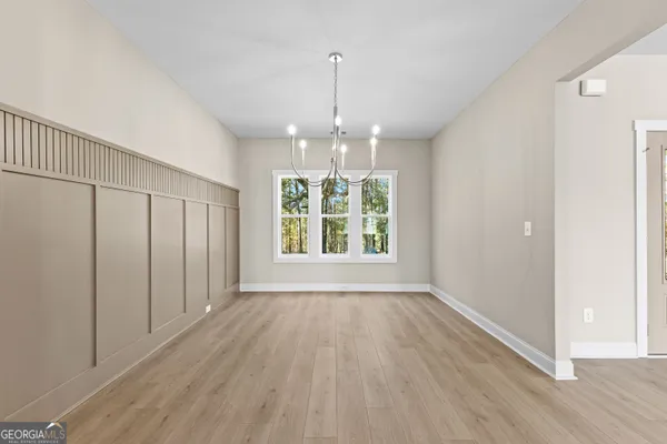 a view of a room with chandelier and wooden floor