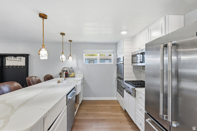 2500 North Fort Lane, Unit 220 Layton, UT 84041 - Photo 4 of 23 Modern kitchen featuring light wood-finish flooring, white cabinetry, and stainless steel appliances