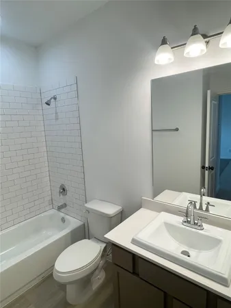 a bathroom with a sink toilet vanity and shower