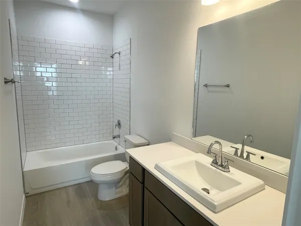 a bathroom with a sink vanity mirror and toilet
