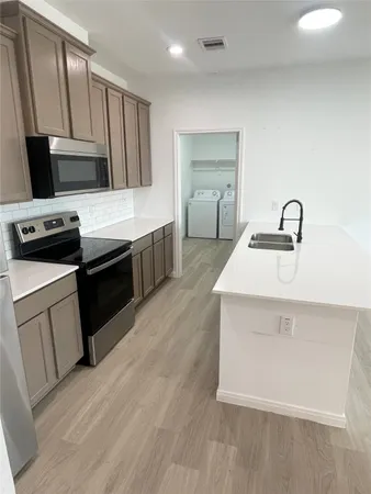 a kitchen with a sink stove and refrigerator