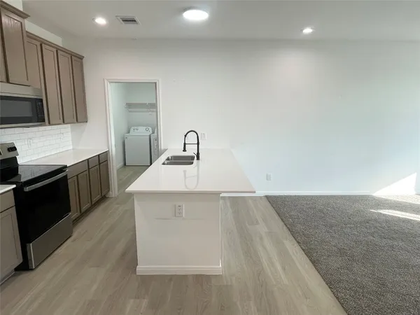 a kitchen with a sink cabinets and appliances