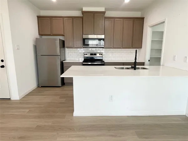 a kitchen with a refrigerator and a stove