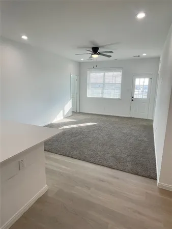 an empty room with windows and cabinet
