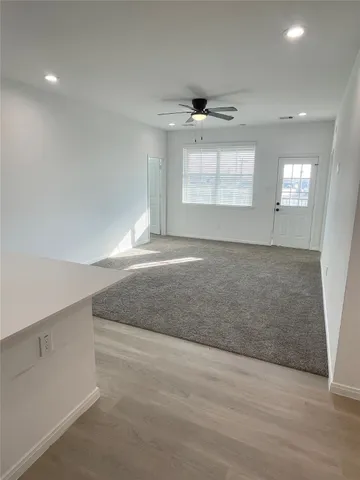 an empty room with windows and cabinet