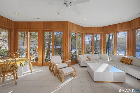 a living room with furniture and floor to ceiling windows