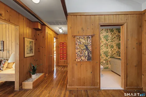 a view of a hallway with wooden floor and staircase